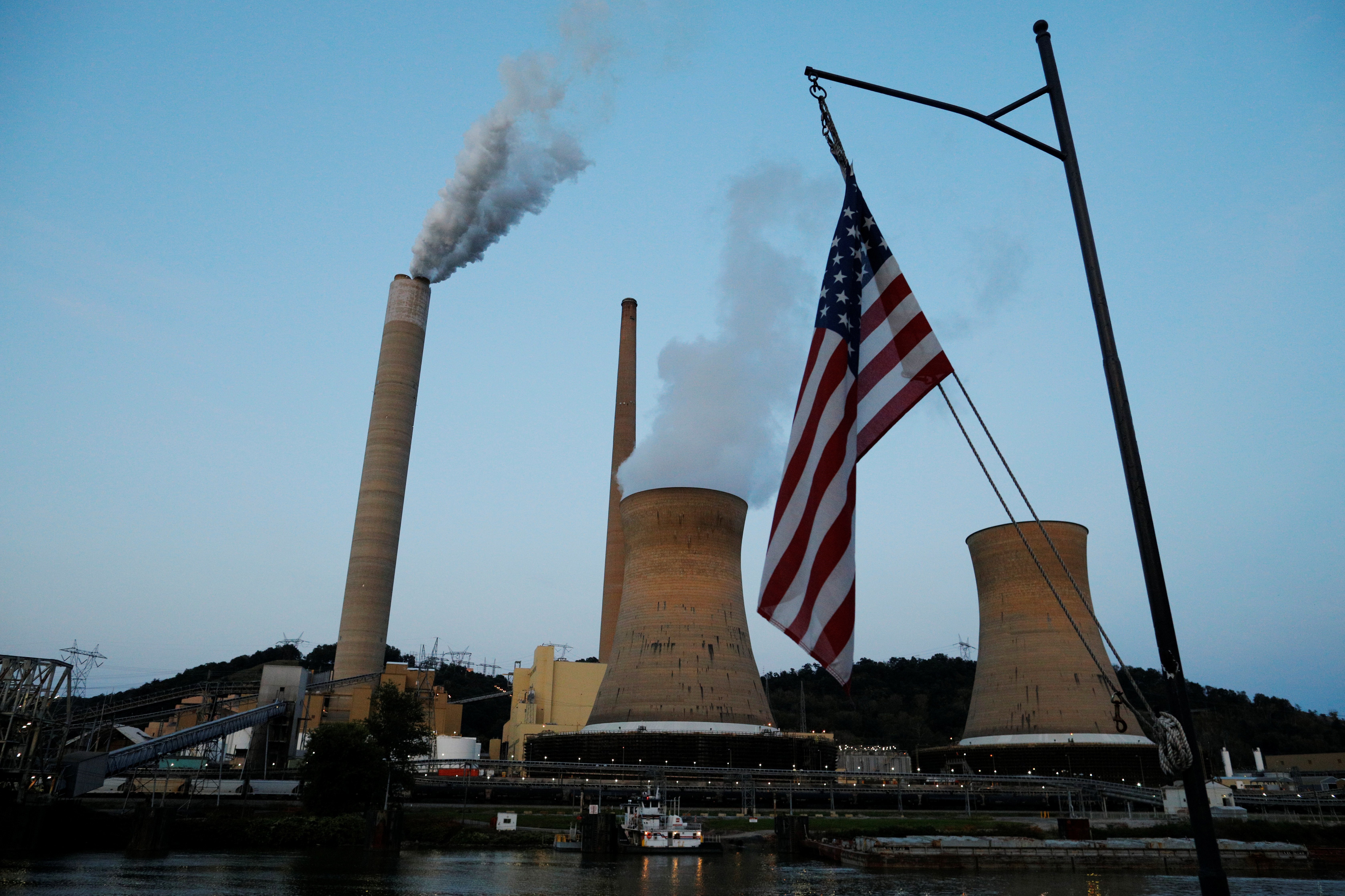 The U.S. flag flies on Campbell Transportation’s towboat M.K. McNally as it passes Mitchell Power Plant, a coal-fired power-plant operated by American Electric Power (AEP), on the Ohio River in Moundsville, West Virginia, U.S., Sept. 10, 2017. REUTERS/Brian Snyder
